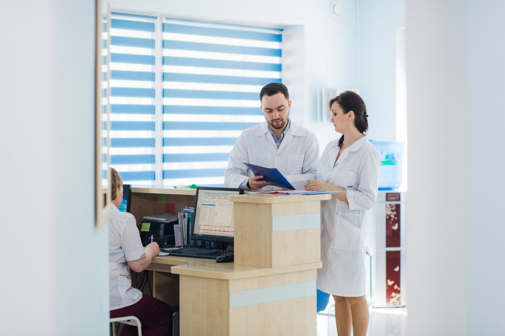 Busy reception in a hospital with doctors and receptionists