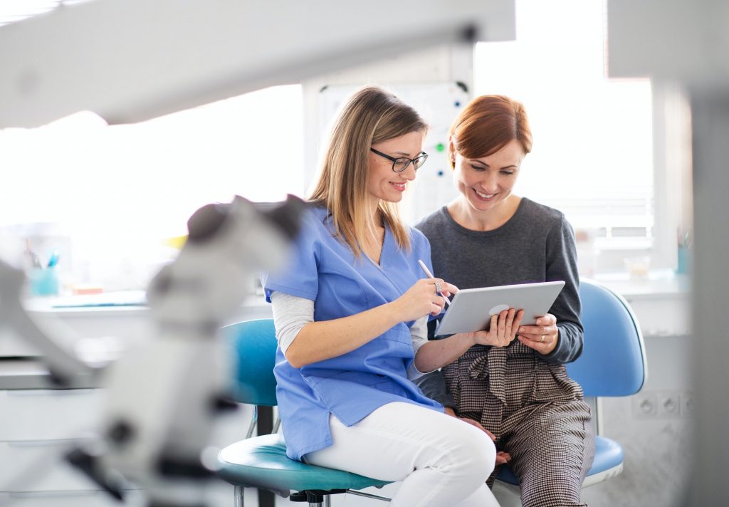 A dentist talking to woman in dentist surgery, a dental check-up