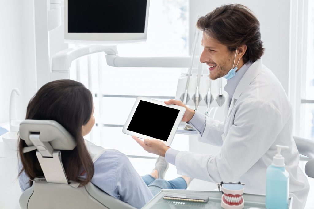 Dentist doctor showing patient blank digital tablet screen