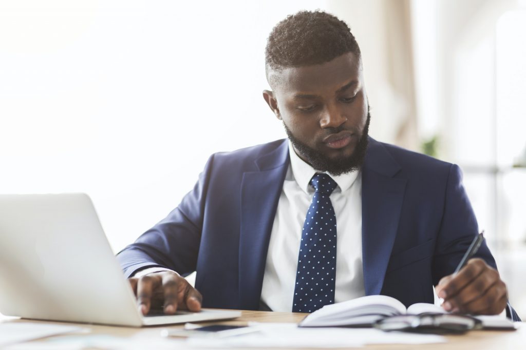 Young businessman making market research, sitting in office